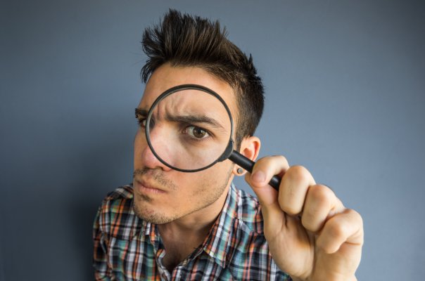 us search online background check service features man looking through magnifying glass